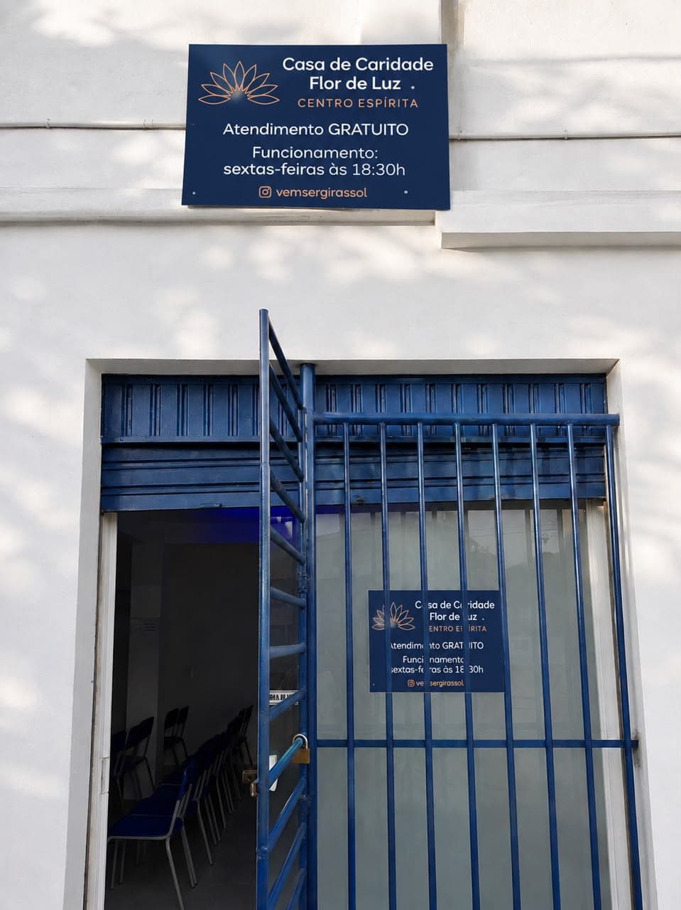 Fachada da Casa de Caridade Flor de Luz, com a placa de identificação e o portão de entrada.